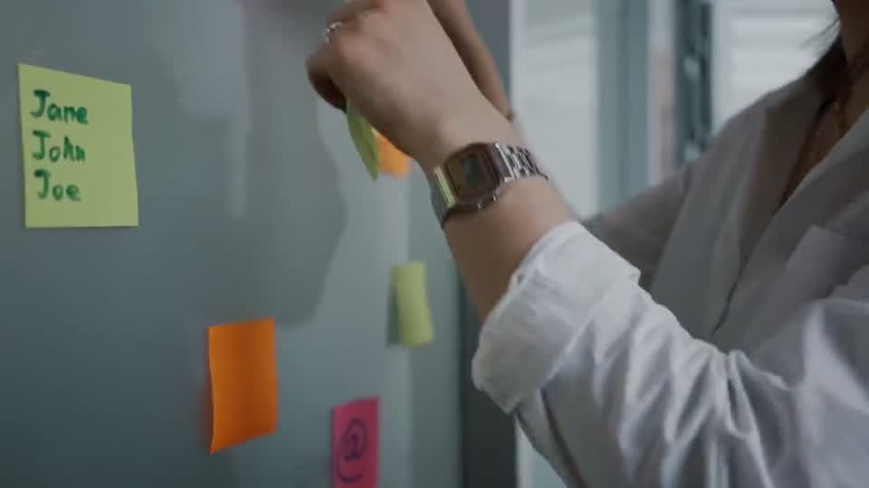 Colleagues planning against a wall of sticky notes